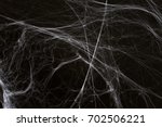 halloween, decoration and horror concept - ecoration of artificial spider web over black background