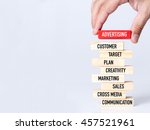 Businessman Building ADVERTISING Concept with Wooden Blocks