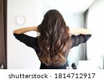Close-up of woman after visiting hairdresser. Long curls of brunette female person. Hairdo for holiday or for everyday. Beauty salon and hairstyle concept