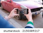 Small photo of Woman holding smartphone and taking picture of car accident. Car insurance and payout concept
