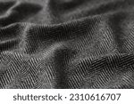 Small photo of Crumpled black herringbone suit fabric with white stripes for sale in clothing store. Soft textile material texture as background. Catalog photo sample
