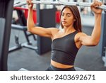 latin American  woman doing wide grip lat pulldown in the gym	