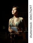 Small photo of Beautiful korean in night. Fine hangup dress, charred paper, black background.