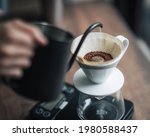 Barista is making drip brewing, filtered coffee, or pour over coffee with hot water and filter paper in coffee shop.vintage tone.