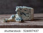 Slices of Danish Blue cheese on an old wooden table, selective focus