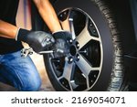 Auto mechanic use wrench to repairing and change car tires. Concept of car care service and maintenance or fix the car leaky or flat tire.