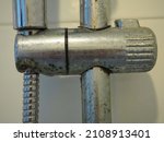 Small photo of Dirty calcified shower mixer tap and shower hose, faucet with limescale or lime scale on it, close up photo, blurred.