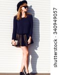 Small photo of autumn fall fashion image of american trill woman posing on white wall,wear trendy urban street clothes,leather skirt,black hat,warm blue sweater.street fashion clothes outdoor,accessory fashion,warm