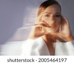 Fashion portrait with the effect of blurring in motion at a long shutter speed, distortion of the model's face. Young stylish woman in a white jacket
