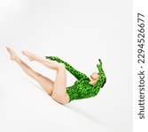 Small photo of Stylish bright dancer in a bright green leopard print bodysuit, posing on the floor, studio photo on a white background. Plastic body, pretentious pose