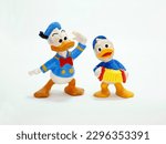 Small photo of Donald Duck and one of his nephews playing the accordion. Huey, Dewey, and Louie. Cartoon characters from Walt Disney. Classic cartoon. Isolated white. Retro plastic doll. Vintage. Sailor. Toys.