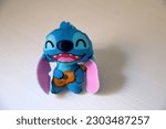 Small photo of Stitch. Lilo y Stitch. Character from the movie Lilo and Stitch. McDonald's happy meal toy. Experiment 626. Blue creature. Walt Disney character. Stitch playing the Hawaiian ukulele.