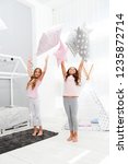 Small photo of Doing whatever they want. Sleepover party ideas. Sisters play pillows bedroom party. Pillow fight pajama party. Girls happy best friends siblings in cute stylish pajamas with pillows sleepover party.