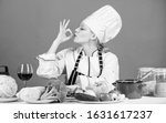 Small photo of Finger licking good. Pretty woman chef gesturing ok. Kitchen maid preparing vitamin food. Professional cook with vitamin vegetables on table. Vitamin nutrition. Getting vitamin the natural way.