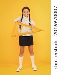 Small photo of A triangle has three sides and three angles. Adorable happy schoolchild holding triangle on yellow background. Cute girl smiling with geometric triangle for geometry lesson. Lesson in triangle