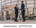 cheerful two business men handshaking. two business men handshaking outdoor.