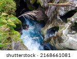 Aeriel view of blue water flowing through weathered rocks in the Chasm, Cleddau River, New Zealand, Fiordland National Park