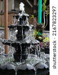 Small stone fountain in tropical garden. Freezing concept in photography with high shutterspeed .