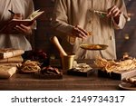Small photo of A moment of apocathery measuring ingredient in gold scale with chinese traditional medicine in wooden table