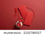 Top view of lucky envelopes and decorative items for Chinese lunar new year on red background. Space for text