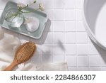 A pastel tray in rectangle shape with a flower vase and a cotton pad placed on, wooden brush with towel and wash basin displayed. Blank space for cosmetic product promotion