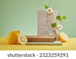 Small photo of Abstract background for presentation product with blocks of stone and fresh lemons on pastel background. Blank space for text and design. Concept of advertising natural cosmetics with lemon extract.