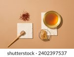 Small photo of A handful of saffrons, honey dripping, golden bowl of honey and a glass petri dish of beeswax. Beige background. Honey helps relieve cough in children