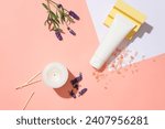 White tube on pink backdrop with Himalayan pink salt, lavender flowers, scented candles, and matches. Perfect for branding with blank labels. Elevate your self-care ritual.