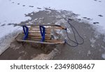 Small photo of Wooden Sled on Thin Ice Lake, Danger of Drowning in Ice-Hole in Winter