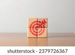 Small photo of Four wooden blocks with red dart symbols. The idea of ​​setting goals and moving towards them. Setting goals for work