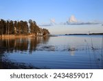 Small photo of Seaside landscape in Espoo, Finland. Calm surface of the Baltic Sea, blue sky and some trees. Beautiful summer evening just before the sun starts to set. Color image.