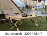 Small photo of sets of camping equipment in the form of tents and camping tables as well as equipment for making portable coffee in the open and in sunny weather