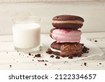 Small photo of American whoopie pie desserts and glass of milk on white wooden planks