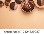 Small photo of American whoopie pie desserts in paper craft boxes on beige background, copy space