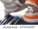 Small photo of Dentist's office. Dentist examines the oral cavity treatment. The doctor shows a course of treatment. Caries treatment. Implantation and installation of veneers.