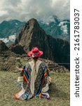 Small photo of Photograph of a tourist woman in Machu Picchu. Traveler with poncho and Inca hat. Wonder of the World. Colors