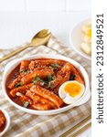Small photo of Topokki or tteokbokki with boiled egg on a white plate. perfect for recipe, article, catalogue, commercial, or any cooking contents. with copy space.