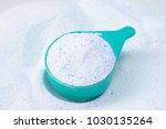 Laundry detergent powder for washing machine and plastic scoop for dosage.