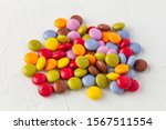 a bunch of colorful chocolate lentils isolated on rustic white background