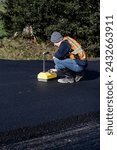 Small photo of KIRKLAND, WA – FEB 23, 2024: Residential street repaving project, technician testing asphalt compaction density with Nuclear Density Gauge
