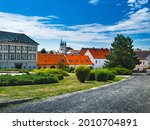 Summer in downtown of Nitra city, Slovakia. Old Town buildings with red roofs at distance, stone street pavement, slovak historical architecture on square under blue sky, famous tourist destination