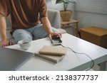 Man hands plugging a charger in a smart phone. Charging Smartphone with Wireless Charging Pad at Home