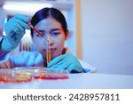 Small photo of Asian female scientist passionately conducts experiments in a laboratory, surrounded by petri dishes and beakers. Delve into the chemistry of gasoline, food ingredients, and perfumes