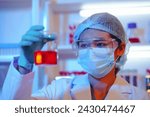 Small photo of Asian female scientist passionately conducts experiments in a laboratory, surrounded by petri dishes and beakers. Delve into the chemistry of gasoline, food ingredients, and perfumes