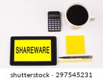 Small photo of Business Term / Business Phrase on Tablet PC with a cup of coffee, Pens, Calculator, and yellow note pad on a White Background - Black Word(s) on a yellow background - Shareware