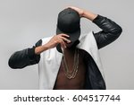 Small photo of Black afroamerican rebellious rapper on grey background. Closed face, rejection, separated, reluctance to see, breaking off. Ghetto, challenge to society, cheeky, cool