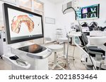 Interior of dental office with modern equipment and dental intraoral scanner with teeth on display, medical system for intraoral scanning. Concept of digital dentistry and dental scanning technology.