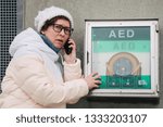 Small photo of medicine cardiopulmonary resuscitation emergency call. Caucasian woman uses telephone calling 911 help. device box aed automatic defibrillator diseases.