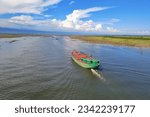 Small photo of Bulkhead boat sailing across the river in a monsoon afternoon