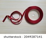 Small photo of AÂ ribbonÂ orÂ ribandÂ is a thin band of material, typicallyÂ cloth, used primarily as decorative binding and tying.